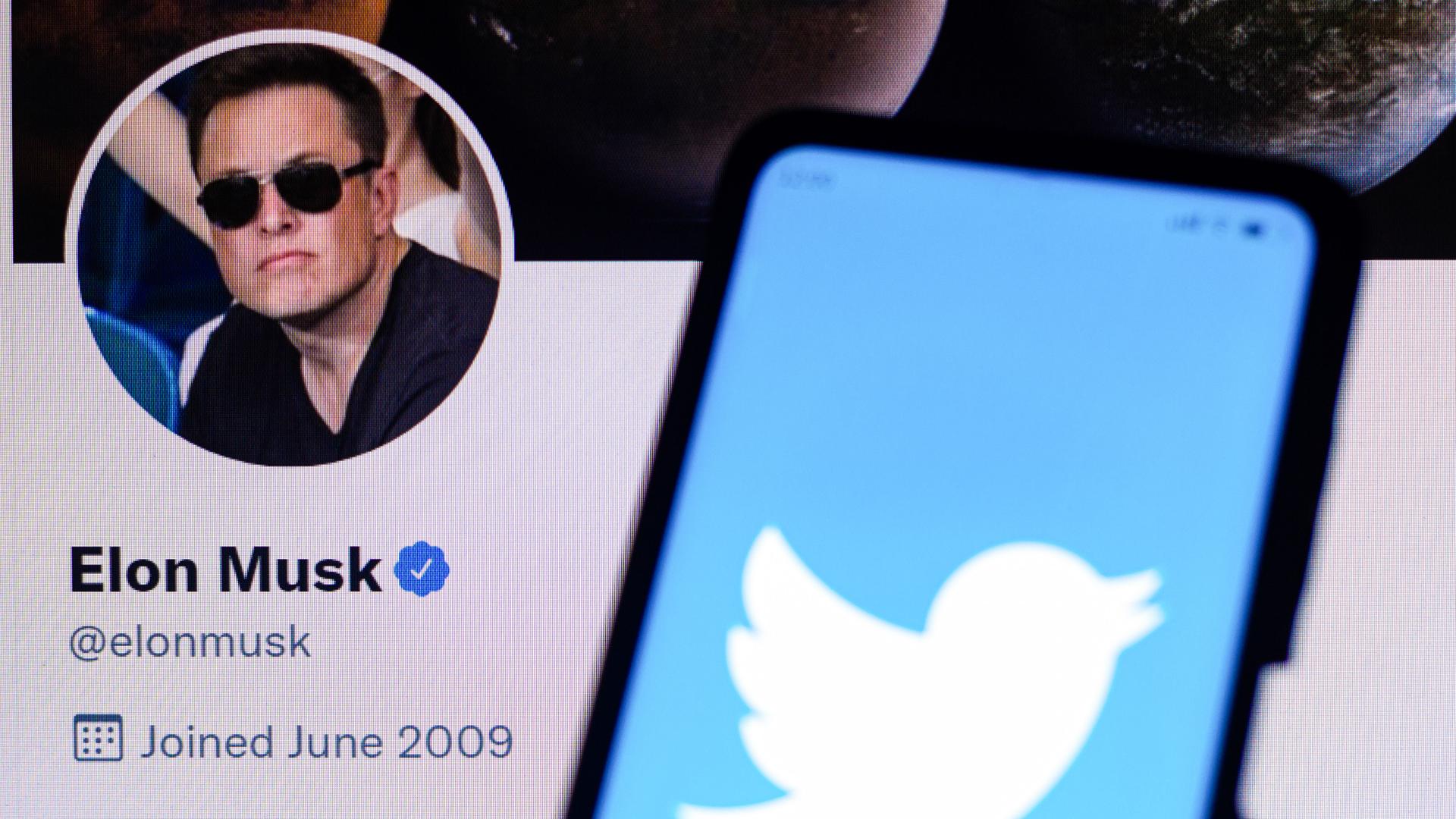 Ein Handy zeigt das Symbol des sozialen Netzwerks Twitter, im Hintergrund ist der Twitter-Account des Tesla-Chefs Elon Musk mit Foto zu sehen. Ein Handy zeigt das Symbol des sozialen Netzwerks Twitter, im Hintergrund ist der Twitter-Account des Tesla-Chefs Elon Musk mit Foto zu sehen.