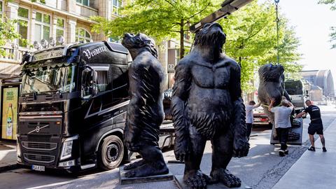 Über drei Meter große Skulpturen von Affen des chinesischen Künstlers Liu Ruowang werden von Technikern von Tiefladern abgeladen und aufgestellt.
