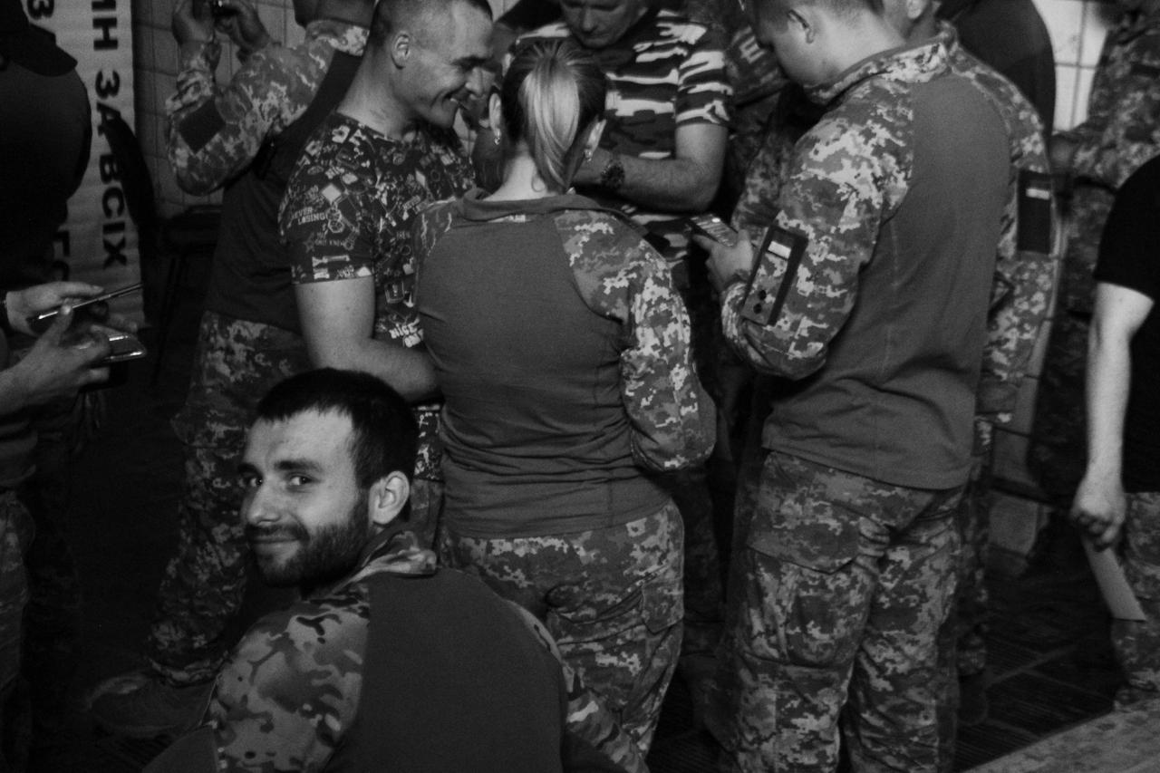 Ein junger Soldat schaut nach Wakartschuks zweitem Gig in die Kamera. Die anderen schauen sich Fotos an, die sie von Wakartschuk gemacht haben. Ein junger Soldat schaut nach Wakartschuks zweitem Gig in die Kamera. Die anderen schauen sich Fotos an, die sie von Wakartschuk gemacht haben.