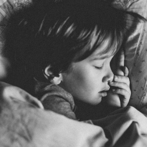 Ein Kind liegt mit geschlossenen Augen im Bett.