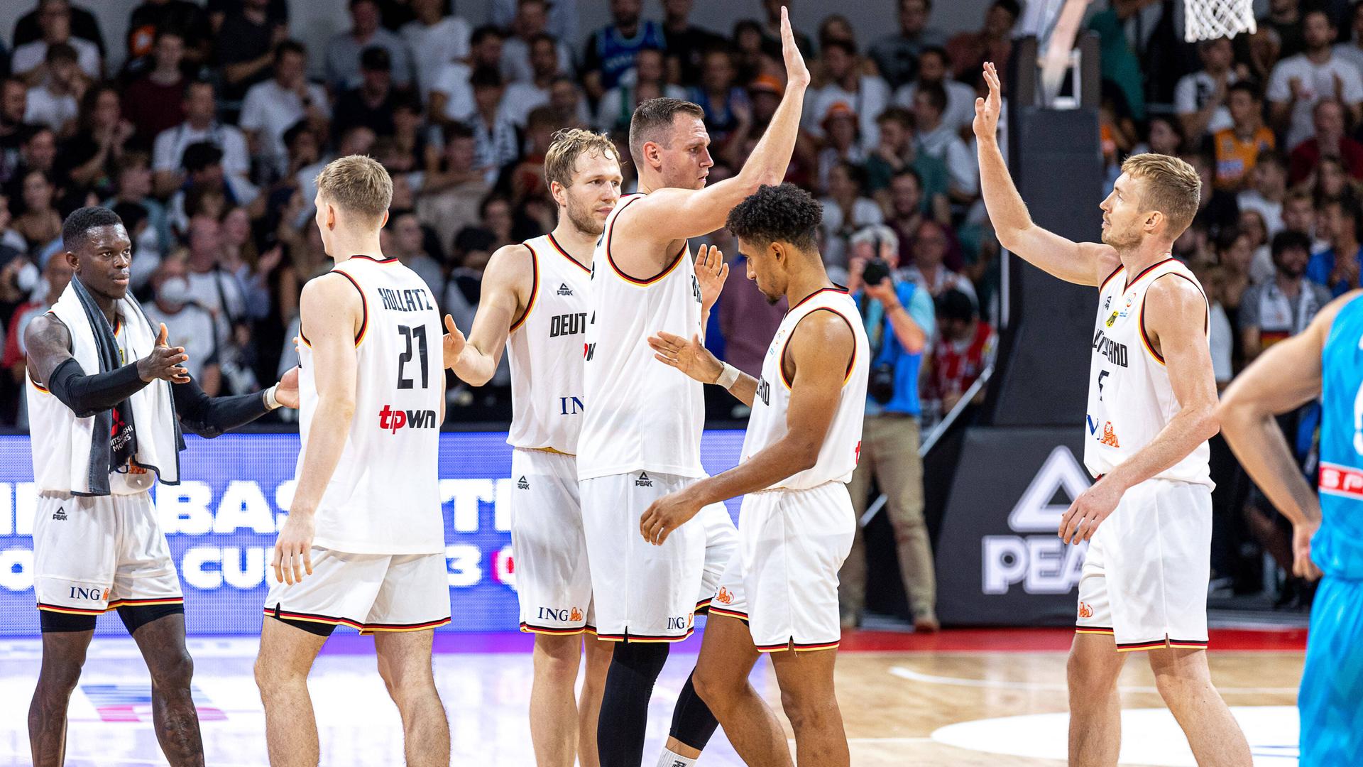 Die deutschen Basketball-Nationalspieler klatschen sich nach dem Sieg gegen Slowenien in der WM-Qualifikation ab. Die deutschen Basketball-Nationalspieler klatschen sich nach dem Sieg gegen Slowenien in der WM-Qualifikation ab.
