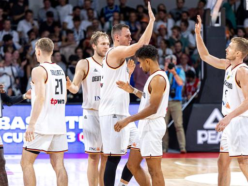 Die deutschen Basketball-Nationalspieler klatschen sich nach dem Sieg gegen Slowenien in der WM-Qualifikation ab.