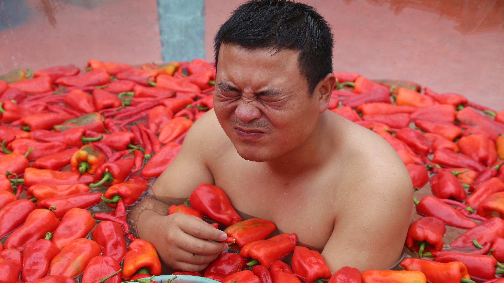 Ein Tourist isst Chili und nimmt ein Bad in der chinesischen Hunan-Provinz, 12 August 2017. Ein Tourist isst Chili und nimmt ein Bad in der chinesischen Hunan-Provinz, 12 August 2017.