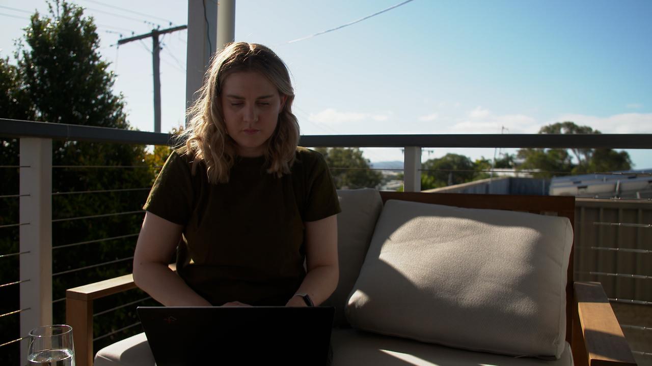 Eine junge blonde Frau sitzt unter blauem Himmel auf einer Couch auf einer Dachterrasse. Eine junge blonde Frau sitzt unter blauem Himmel auf einer Couch auf einer Dachterrasse.