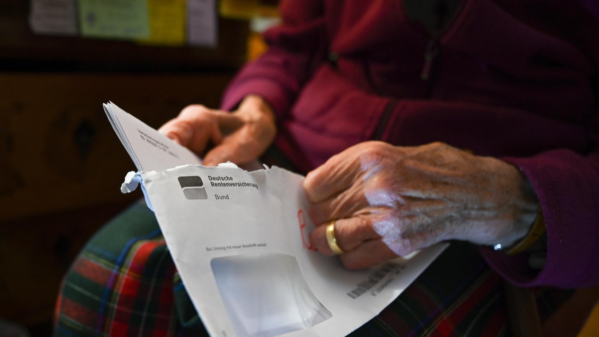 Eine Seniorin hält ihren Rentenbescheid in der Hand Eine Seniorin hält ihren Rentenbescheid in der Hand