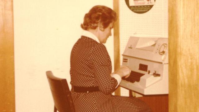 Eine Frau sitzt an einem Fernschreiber, 1972