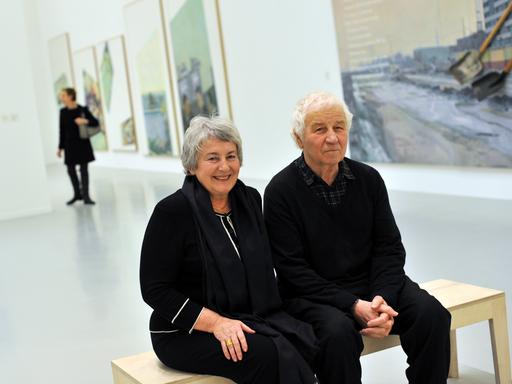 Der Künstler Ilja Kabakow sitzt mit seiner Frau Emilia Kabakow auf einer Bank vor seinen Werken bei einer Ausstellungseröffnung im Sprengel-Museum in Hannover. 