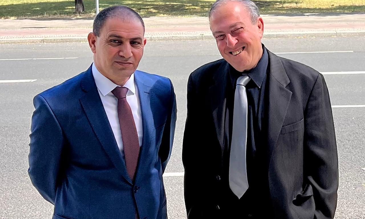 Der Palästinenser Bassam Aramin und der Israeli Rami Elhanan stehen beide im Anzug nebeneinander. Der Palästinenser Bassam Aramin und der Israeli Rami Elhanan stehen beide im Anzug nebeneinander.