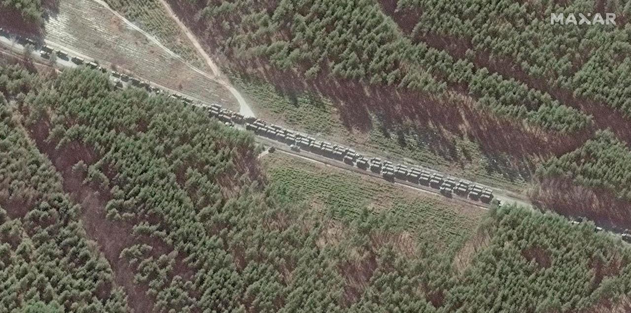 Ein Militärkovoi ist aus der Luft zu sehen, auf einer Straße durch einen Wald. Ein Militärkovoi ist aus der Luft zu sehen, auf einer Straße durch einen Wald.