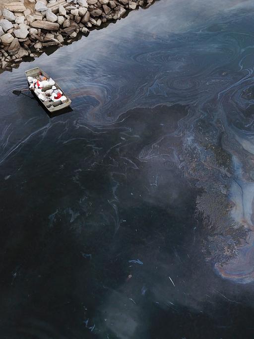Eine Luftaufnahme vom 4. Oktober 2021 zeigt Umweltschutzteams, die nach einem Ölunfall im Pazifischen Ozean in Huntington Beach, Kalifornien, das Öl beseitigen, das ausgelaufen ist und einen Schimmer auf dem Wasser verursacht hat.