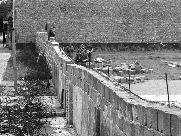 Volkspolizisten und Arbeiter der DDR beim Errichten der Berliner Mauer am 6.10.1961 im Norden Berlins, an der Grenze zum westberliner Bezirk Reinickendorf. 