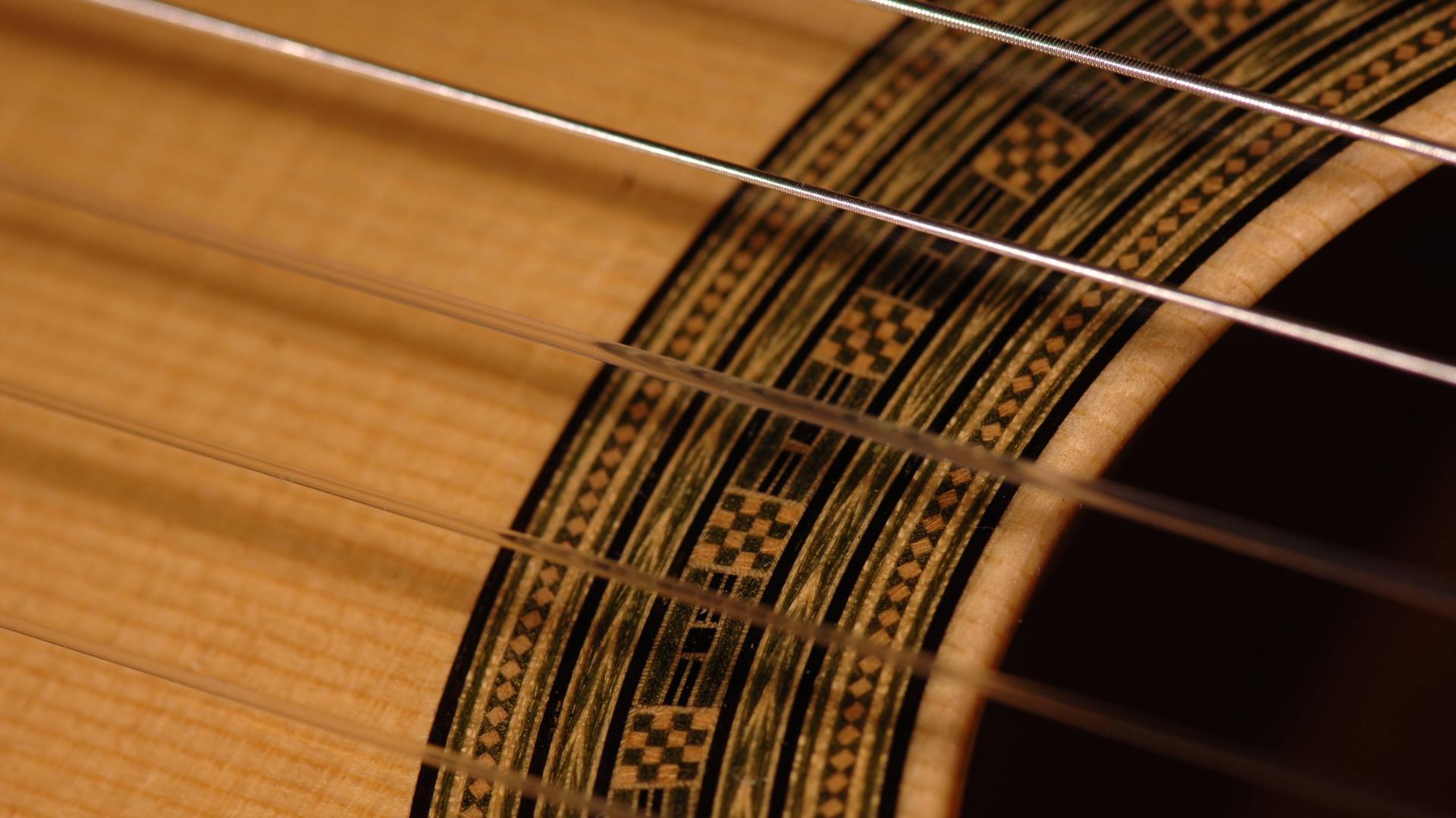 Saiten einer akustischen Gitarre am Schallloch. Saiten einer akustischen Gitarre am Schallloch.