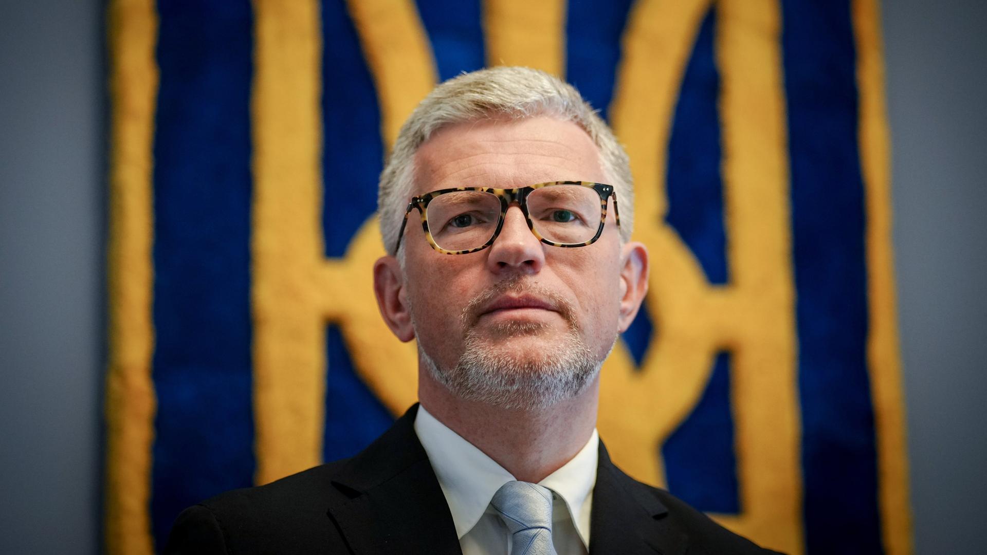 Andrij Melnyk, Botschafter der Ukraine in Deutschland, blickt vor dem Wappen der Ukraine im Botschaftsgebäude am Rande eines Gesprächs mit Journalisten in die Kamera des Fotografen. Andrij Melnyk, Botschafter der Ukraine in Deutschland, blickt vor dem Wappen der Ukraine im Botschaftsgebäude am Rande eines Gesprächs mit Journalisten in die Kamera des Fotografen.
