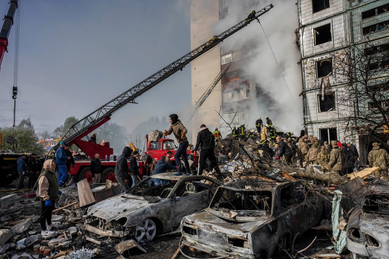 Aus einem Wohnblock in Uman in der Ukraine steigt Rauch aus. Die Fensterscheiben sind zerstört. Vor dem Haus stehen viele Menschen auf einem Schutthaufen. Es sind ausgebrannte Autos zu sehen. Aus einem Wohnblock in Uman in der Ukraine steigt Rauch aus. Die Fensterscheiben sind zerstört. Vor dem Haus stehen viele Menschen auf einem Schutthaufen. Es sind ausgebrannte Autos zu sehen.