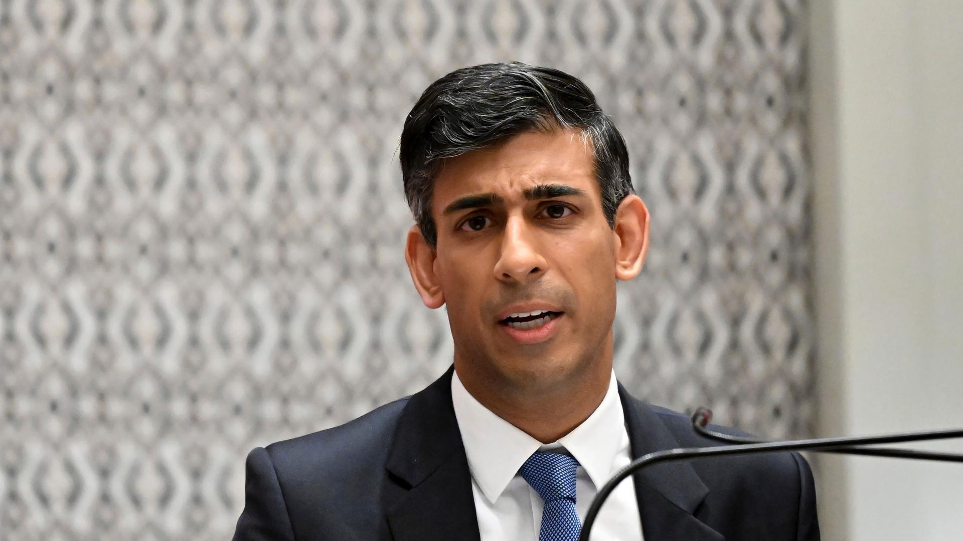 Rishi Sunak spricht an einem Redepult in ein Mikrofon. Rishi Sunak spricht an einem Redepult in ein Mikrofon.
