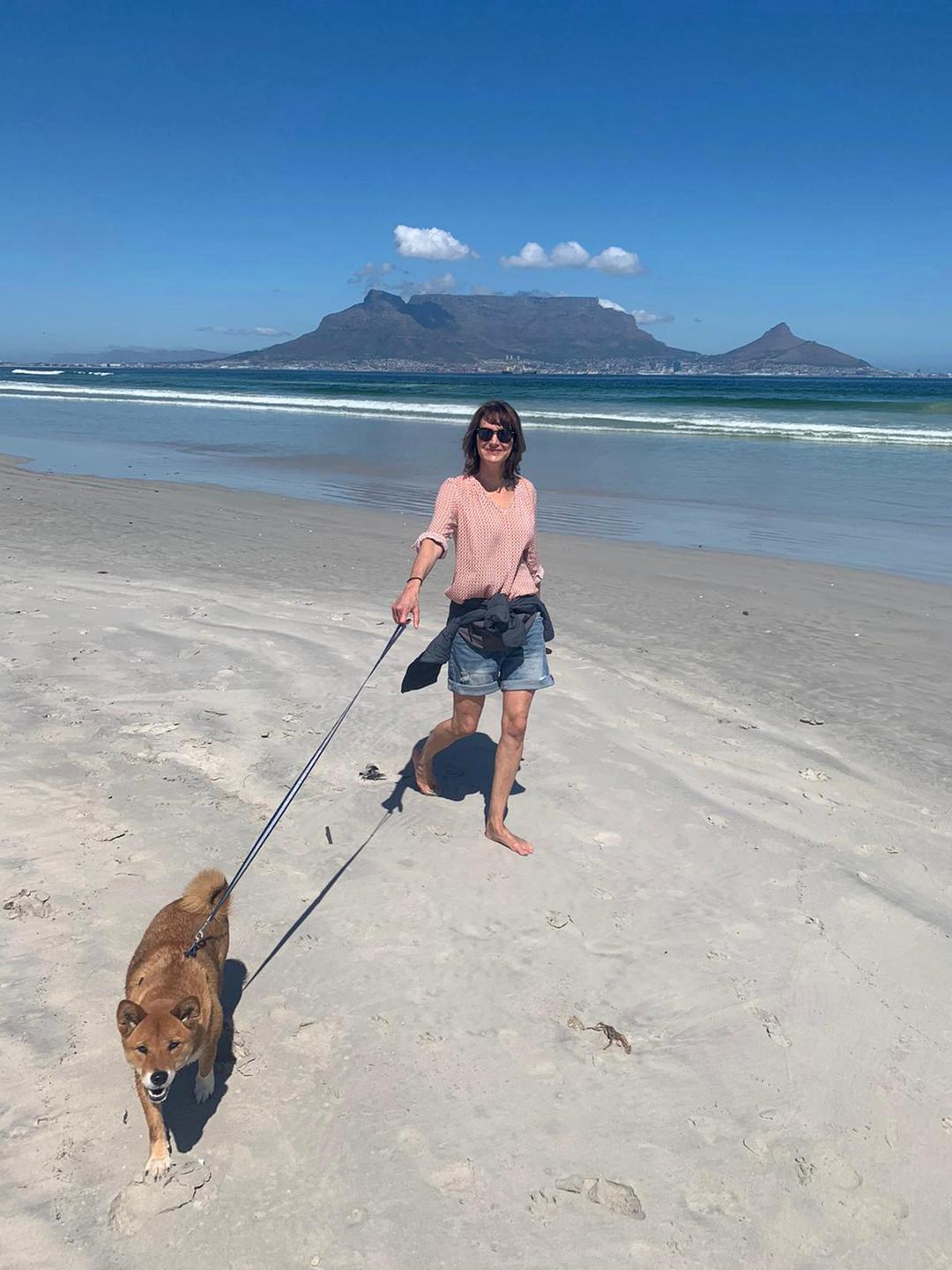 Anja Medau am Strand mit einem Hund an der Leine