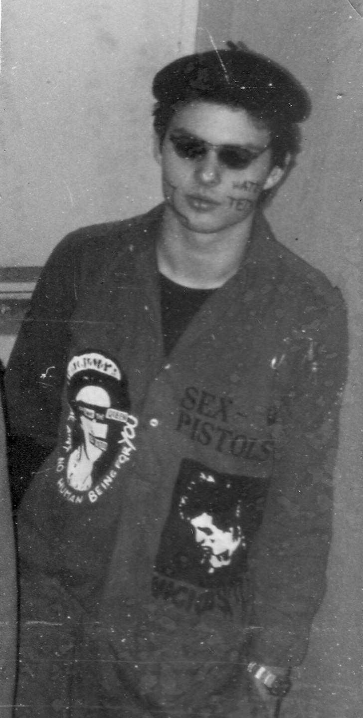 Michael Kobs als junger Mann trägt einen Overall mit Motiven der Band Sex Pistols.