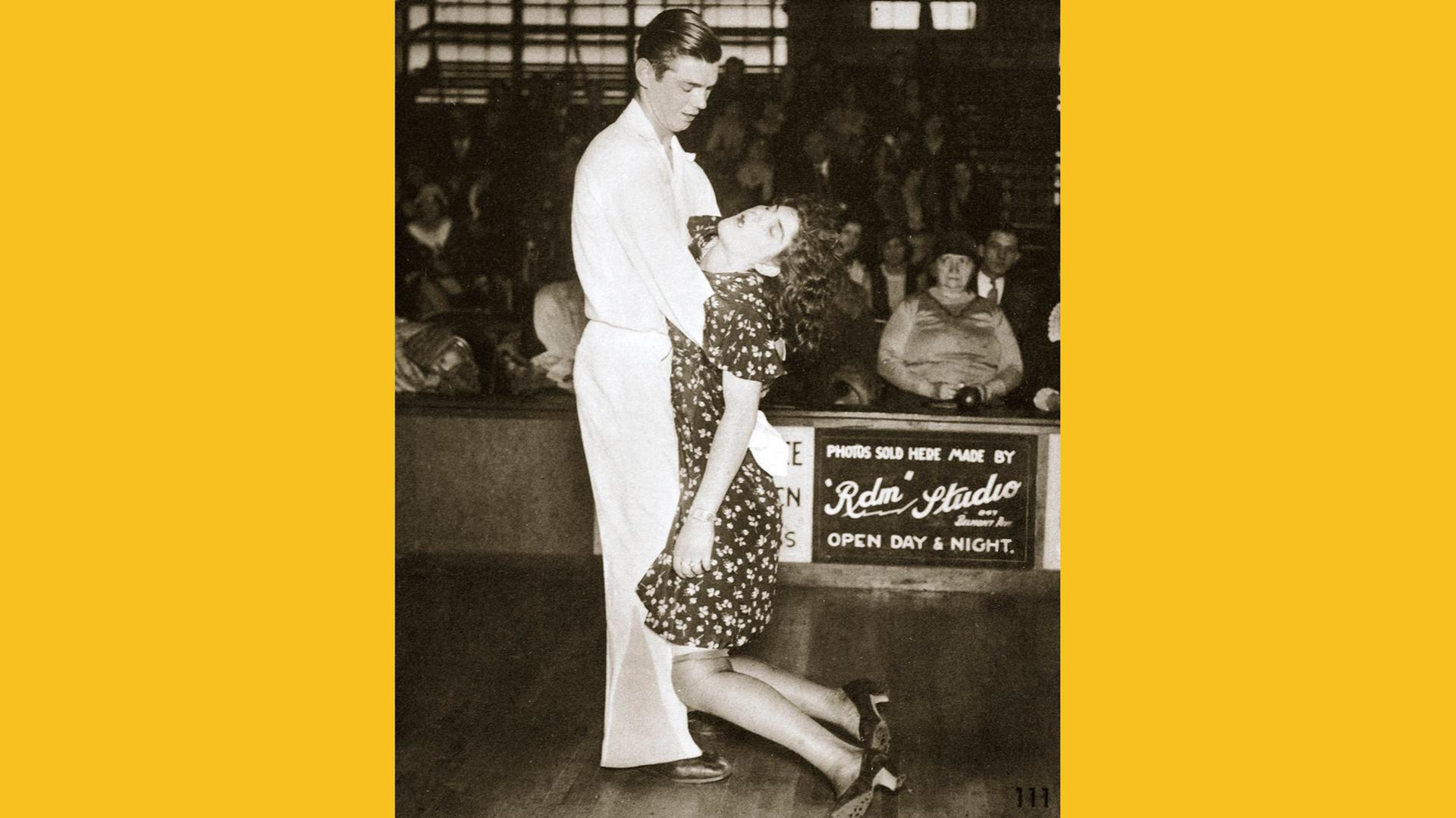 Teilnehmer an einem Tanzmarathon in den USA, 1930. Zu sehen: Auf einer Tanzfläche ein Paar. Der Mann hält eine Frau, die eingeschlafen ist 