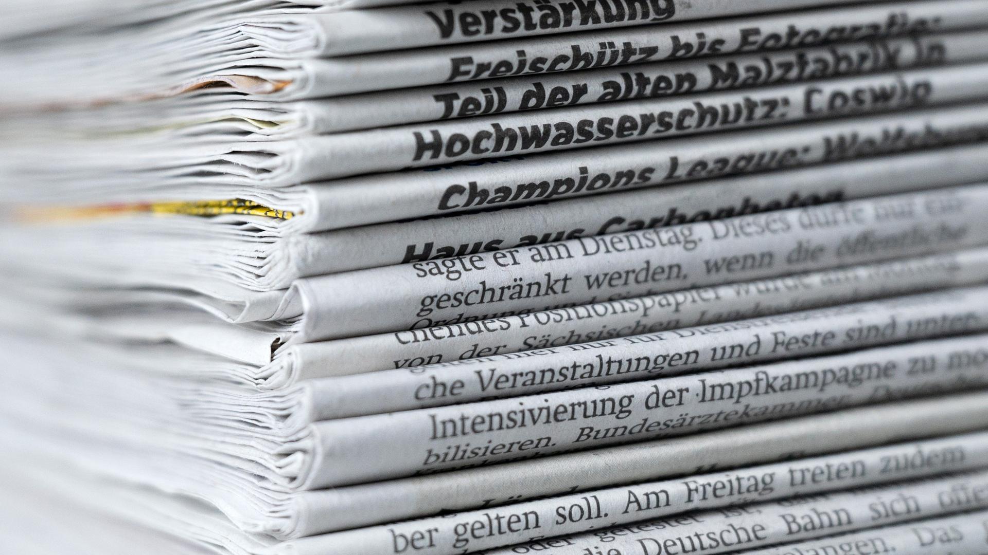 Ein Stapel mit verschiedenen Tageszeitungen liegt auf einem Tisch. Ein Stapel mit verschiedenen Tageszeitungen liegt auf einem Tisch.