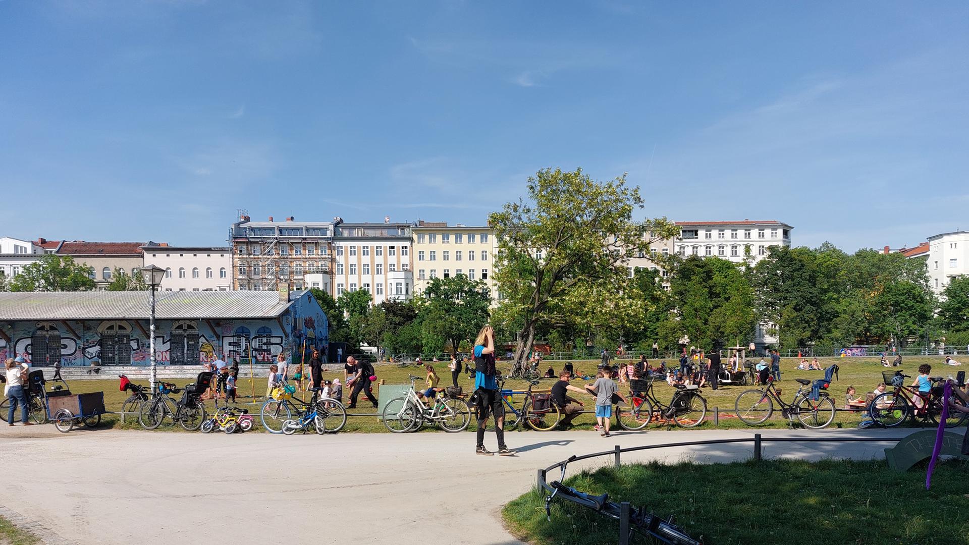 Der Görlitzer Park in Berlin-Kreuzberg bei sommerlichen Temperaturen. Im Vordergrund Besucherinnen und Besucher des Parks, im Hintergrund eine Häuserfront. Der Görlitzer Park in Berlin-Kreuzberg bei sommerlichen Temperaturen. Im Vordergrund Besucherinnen und Besucher des Parks, im Hintergrund eine Häuserfront.