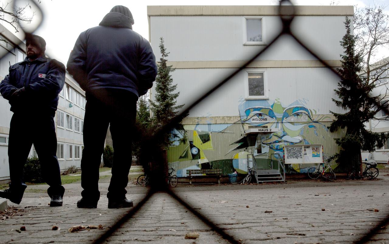 Sicherheitspersonal steht auf dem Gelände einer Flüchtlingsunterkunft in Berlin Spandau.