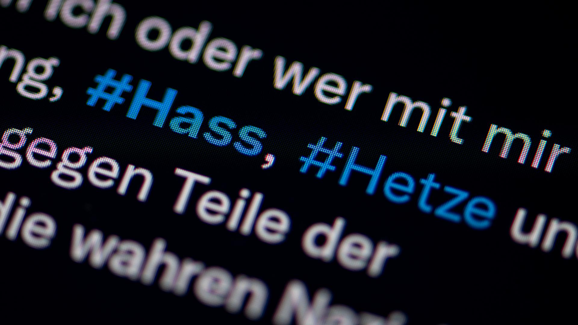Auf dem Bildschirm eines Smartphones sieht man die Hashtags Hass und Hetze in einem Twitter-Post Auf dem Bildschirm eines Smartphones sieht man die Hashtags Hass und Hetze in einem Twitter-Post