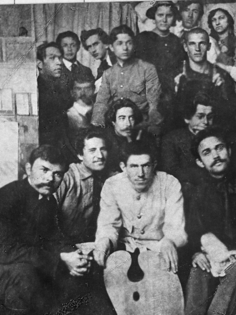 Wladimir Wladimirowitsch Majakowski sitzt umringt von Kollegen und posiert für ein Gruppenfoto.