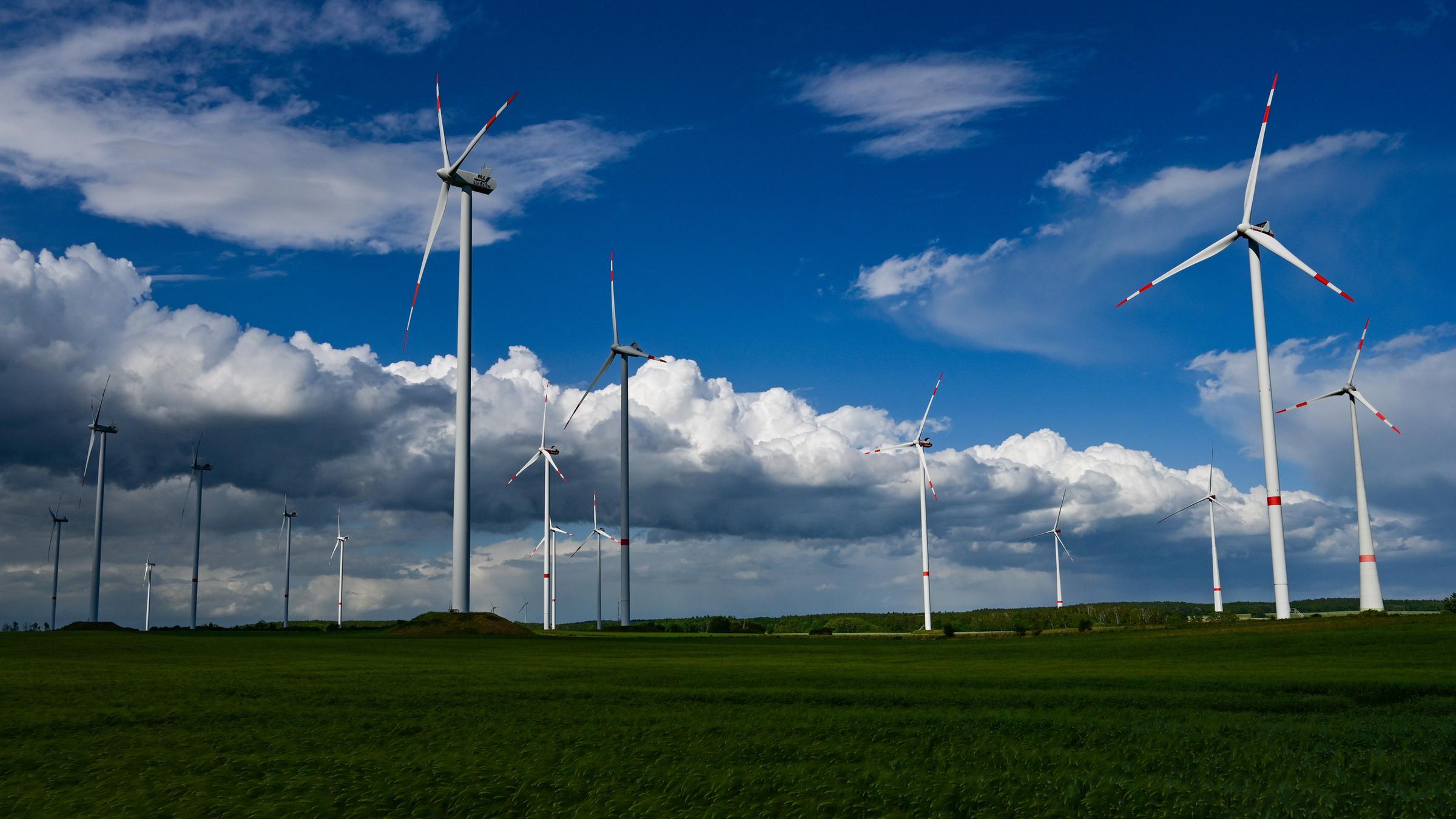 Dunkle Regenwolken ziehen über die Landschaft mit einem Windenergiepark im Landkreis Oder- Spree