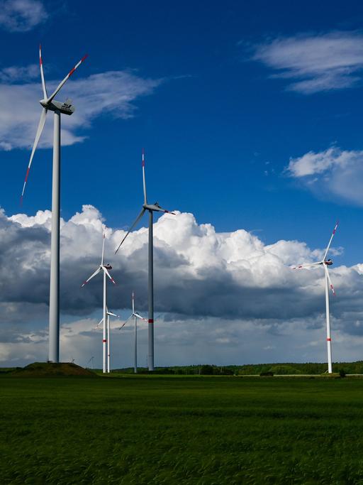 Dunkle Regenwolken ziehen über die Landschaft mit einem Windenergiepark im Landkreis Oder-Spree