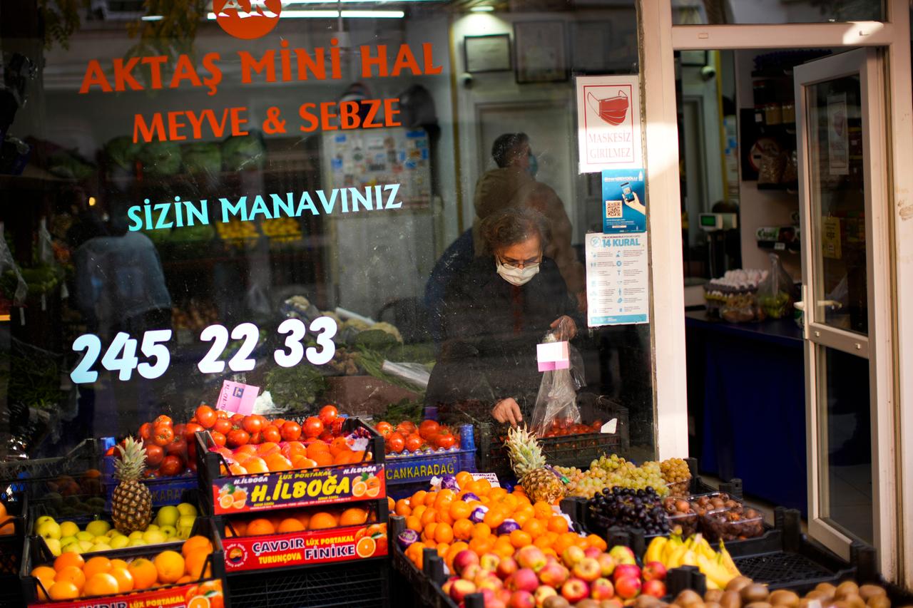 Eine Frau kauft Tomaten in einem türkischen Lebensmittelgeschäft. 