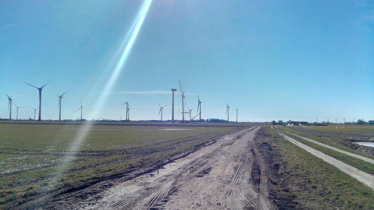 Windräder in Trennewurth, Schleswig-Holstein. Neben einem Windrad ist ein Kran aufgebaut, die Rotorblätter sind bereits demontiert. Windräder in Trennewurth, Schleswig-Holstein. Neben einem Windrad ist ein Kran aufgebaut, die Rotorblätter sind bereits demontiert.