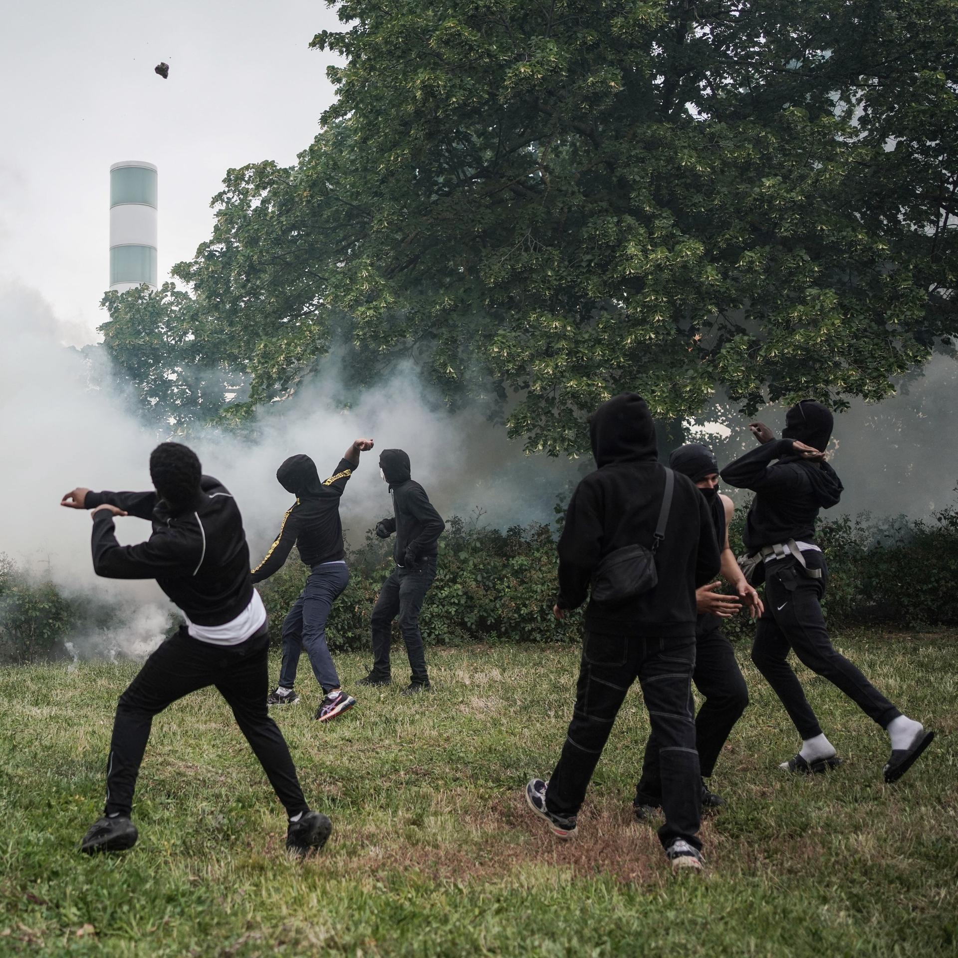 Jugendliche Demonstranten werfen Gegenstände bei Zusammenstößen mit der französischen Polizei am 29. Juni 2023 in Nanterre, Frankreich.