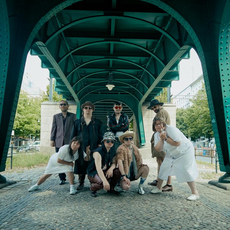 Das Ensemble von "Einer flog übers Kuckucksnest" steht unter den Stützfeilern einer Hochbahn in Berlin.