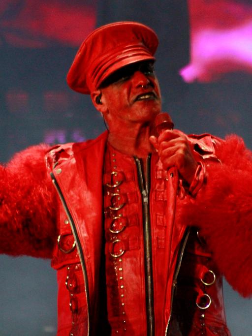 Till Lindemann in rotem Konstüm auf der Bühne bei einem Konzert seiner Band Rammstein.