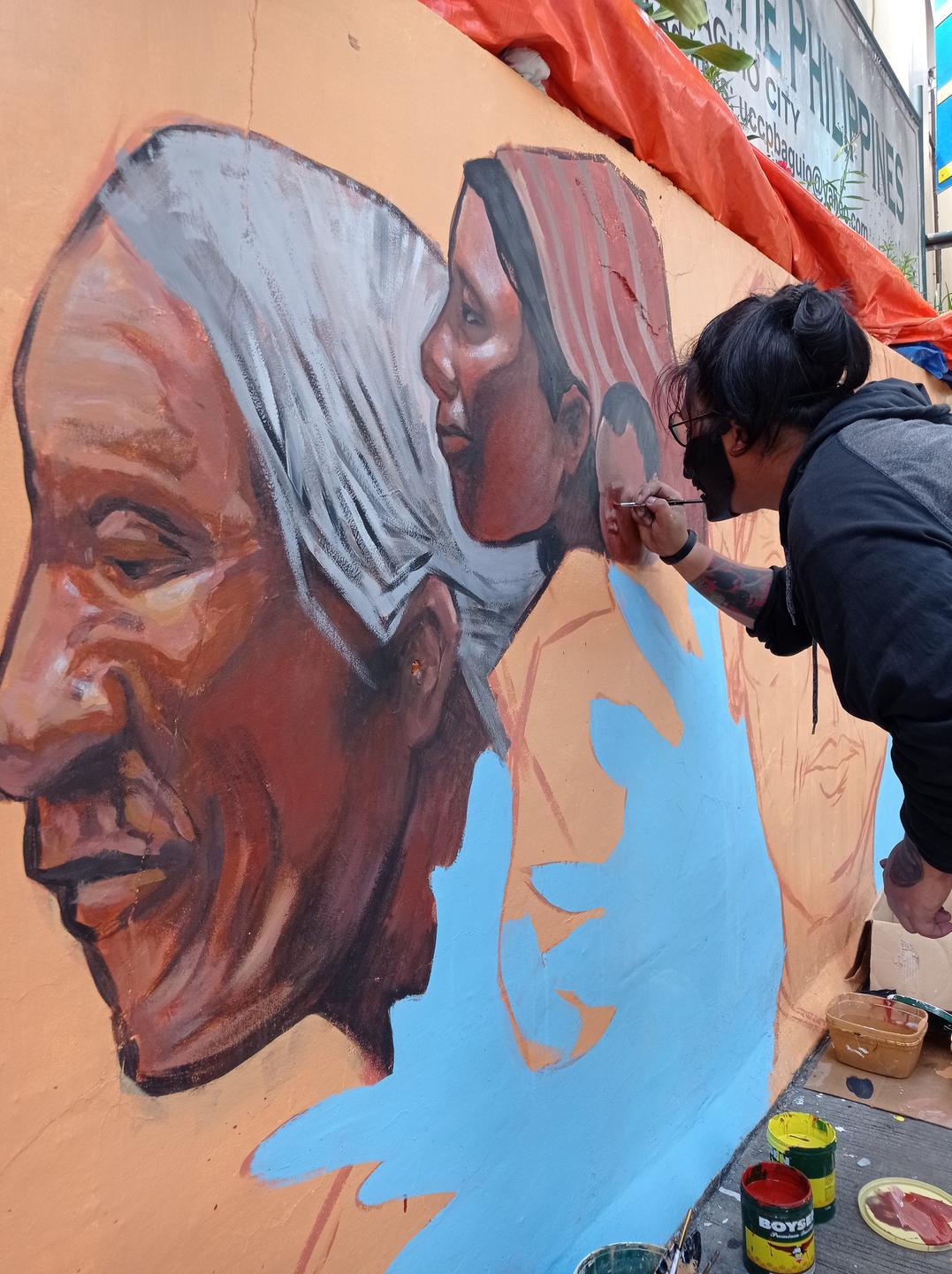 Eine Frau malt ein Mural. Eine Frau malt ein Mural.