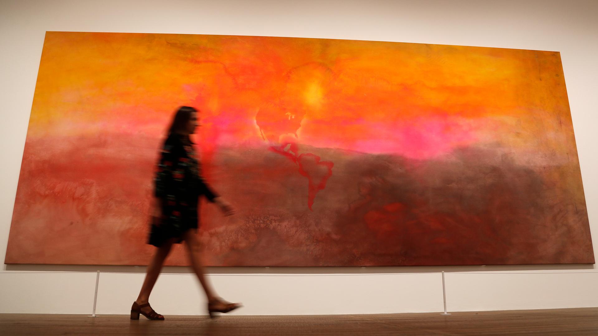 Das abstrakte Gemälde "Texas Louise" von Frank Bowling, davor eine Frau die daran vorbeigeht