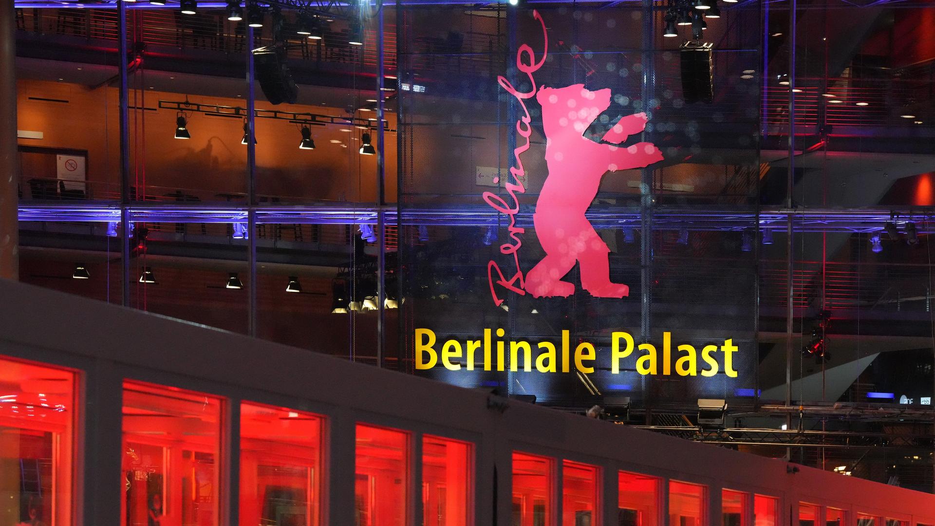 Das Foto zeigt eine Haus-Wand aus Glas. Darauf sieht man einen großen Bären. Neben dem Bären steht "Berlinale". Auf dem Haus steht "Berlinale Palast". Das Foto zeigt eine Haus-Wand aus Glas. Darauf sieht man einen großen Bären. Neben dem Bären steht "Berlinale". Auf dem Haus steht "Berlinale Palast".
