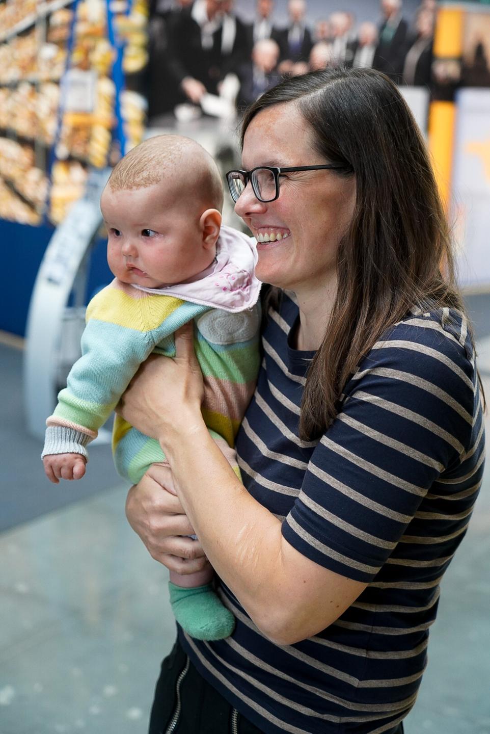 Eine Frau hält ein Baby auf dem Arm. Eine Frau hält ein Baby auf dem Arm.