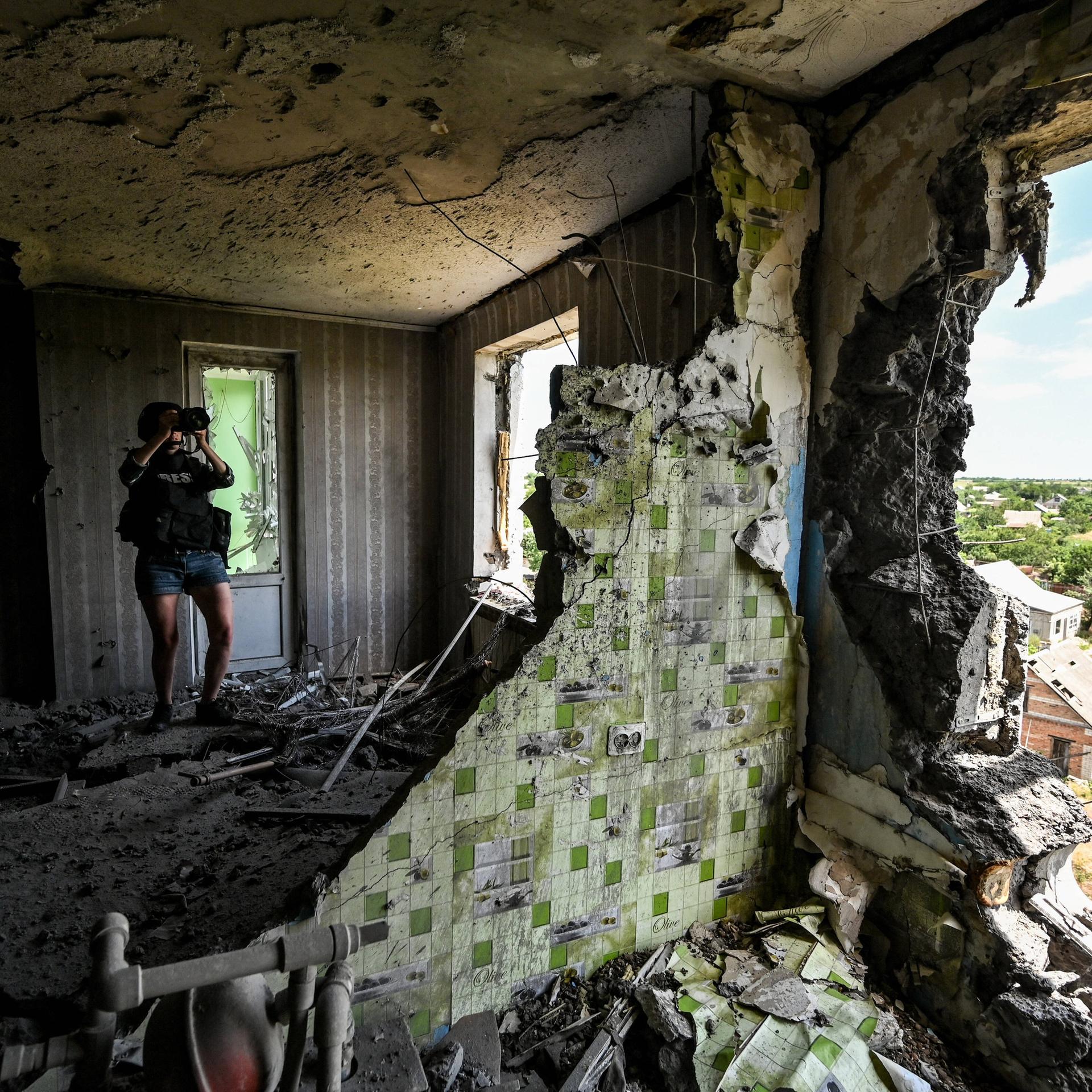 Ein Journalist fotografiert die Auswirkungen eines russischen Angriffs in der Region Saporischschja im Südosten der Ukraine