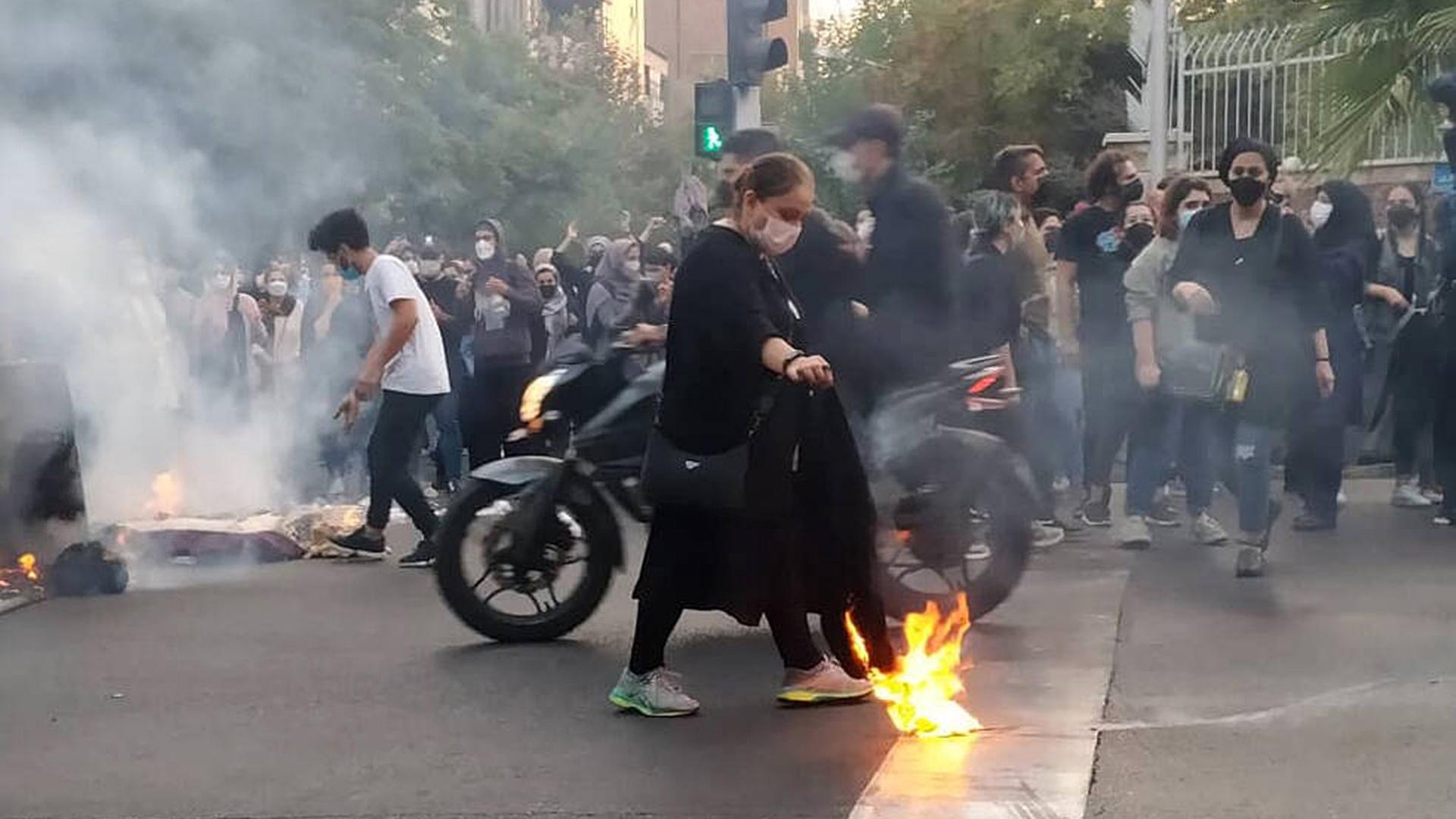 Unruhen im Iran 2022. Leute versammeln sich auf der Straße und zünden Protestfeuer an.