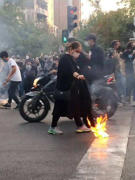 Unruhen im Iran 2022. Leute versammeln sich auf der Straße und zünden Protestfeuer an.