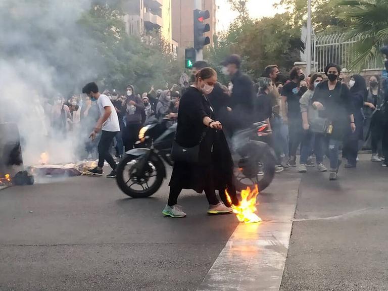 Unruhen im Iran 2022. Leute versammeln sich auf der Straße und zünden Protestfeuer an.