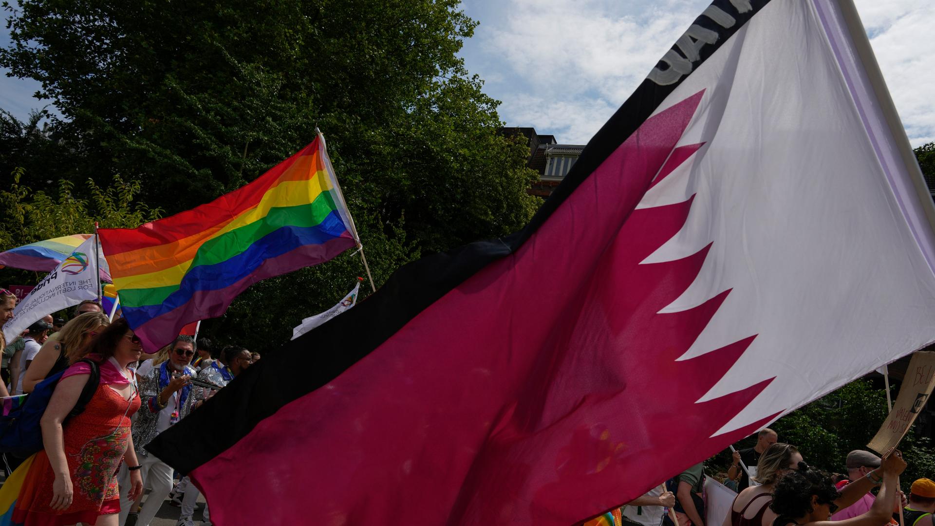 Teilnehmer beim Pride Day in Amsterdam schwenken die Regenbogen-Fahnen und die Flagge von Katar. (AP Photo/Peter Dejong) Teilnehmer beim Pride Day in Amsterdam schwenken die Regenbogen-Fahnen und die Flagge von Katar. (AP Photo/Peter Dejong)