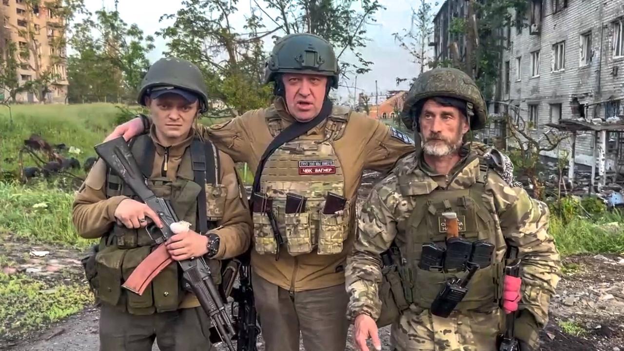 Der Gründer der Wagner Söldnertruppe Jewgeni Prigoschin steht mit zwei seiner Soldaten vor einem zerstörten Strassenzug inder ukrainischen Stadt Bachmut.