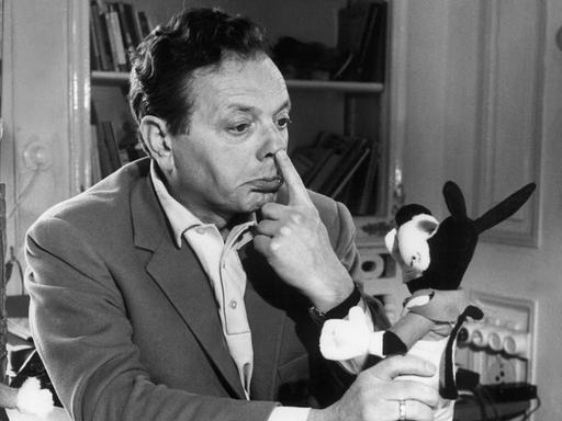 Der populäre deutsche Zeichner und Herausgeber der beliebten "Fix und Foxi"-Comics, Rolf Kauka, sitzt an seinem Schreibtisch und macht Faxen mit einem "Lupo" aus Plüsch.