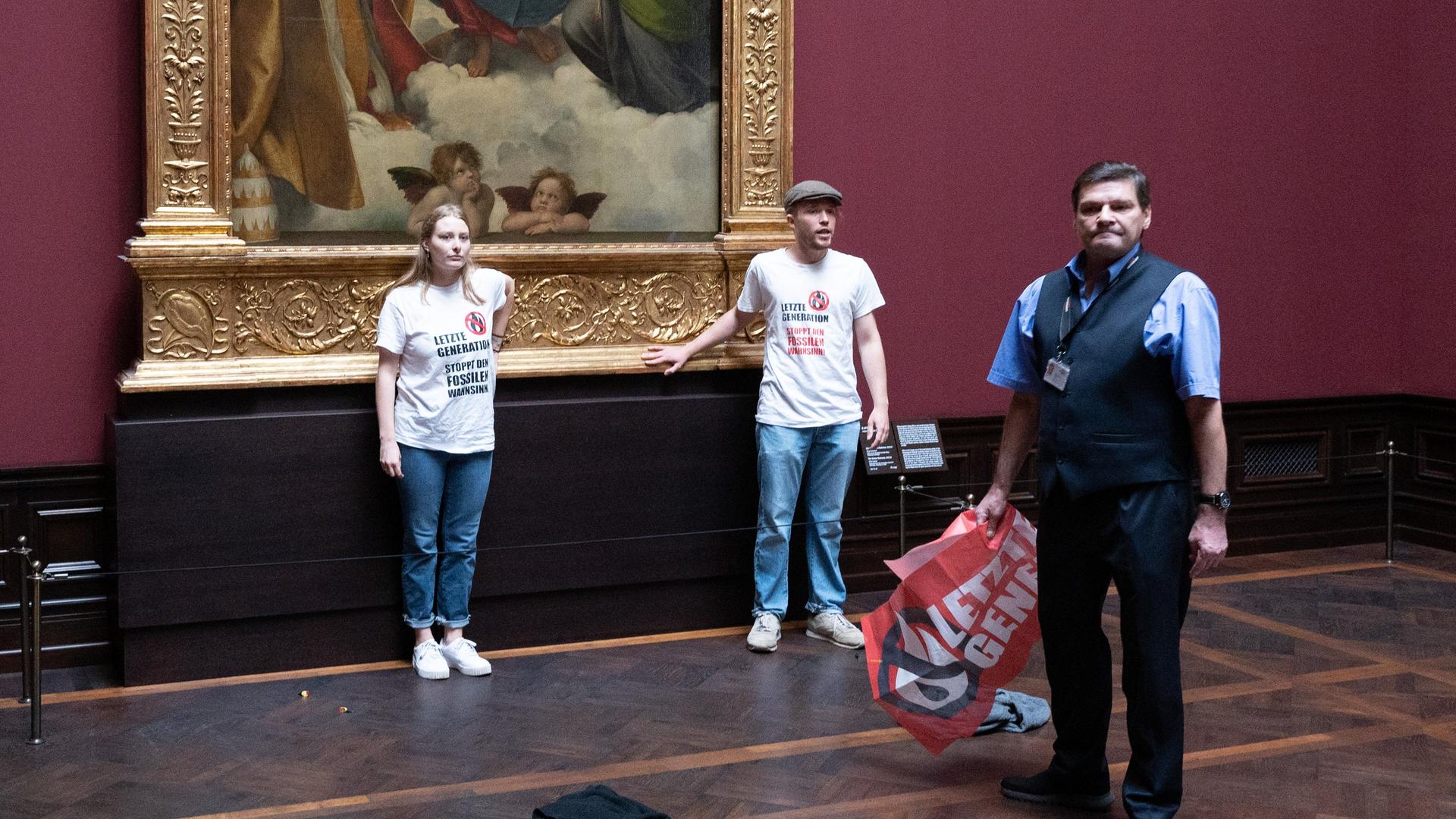 Dresden: Zwei Umweltaktivisten der Gruppe "Letzte Generation" stehen in der Gemäldegalerie Alte Meister an dem Gemälde "Sixtinische Madonna" von Raffael.