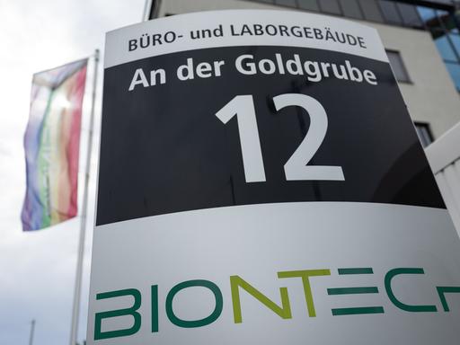 Firmenschild des Unternehmens Biontech mit Flagge im Hintergrund. Der rheinland-pfälzische Wissenschaftsminister Clemens Hoch sieht Rheinland-Pfalz bei der Entwicklung zu einem führenden Standort in der Biotechnologie auf einem guten Weg.