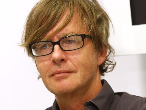 Der Schriftsteller Jörg-Uwe Albig im dunklen Hemd und mit schwarzer Brille