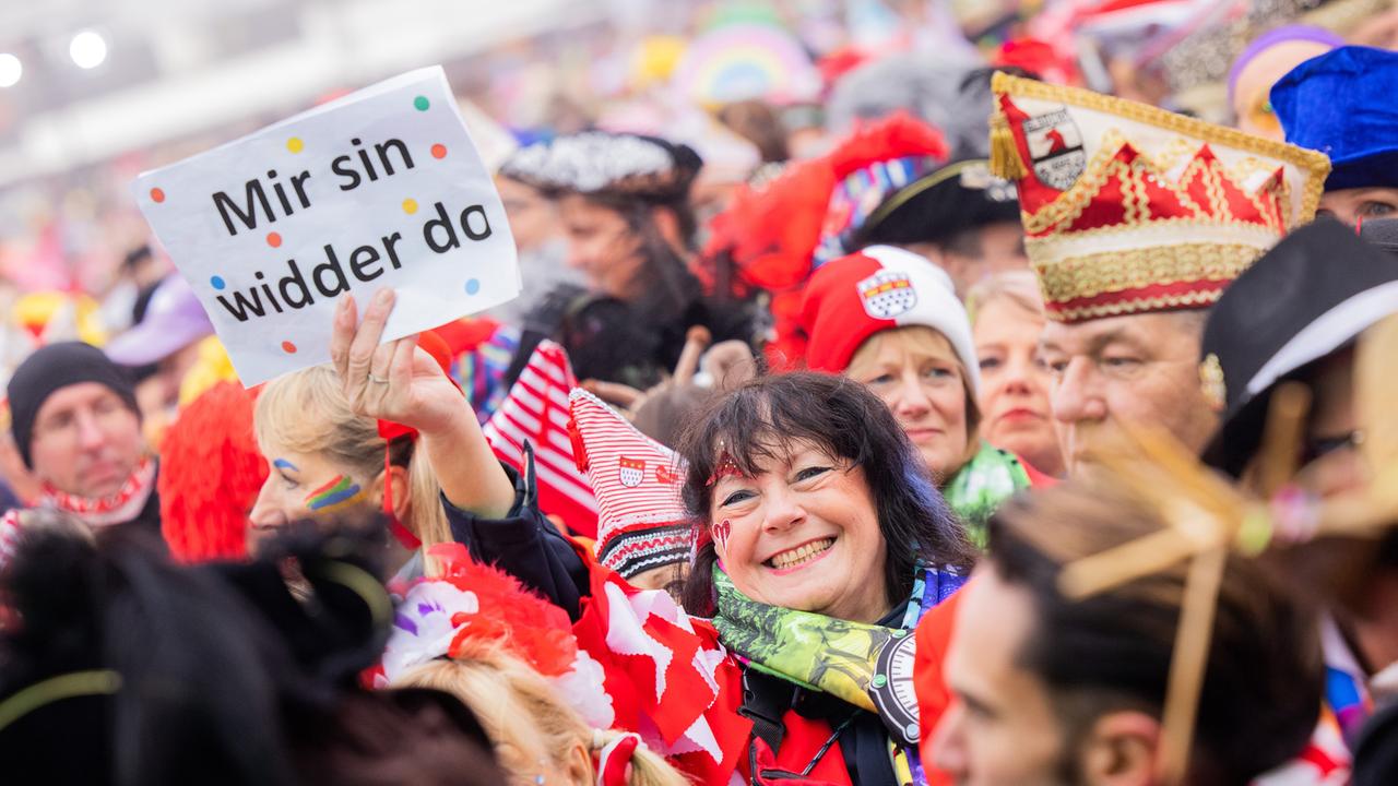 Karnevalistin in Köln mit Schild "Mir sin widder do" Karnevalistin in Köln mit Schild "Mir sin widder do"