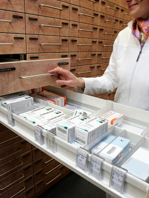 Eine Apothekerin nimmt in Hannover am 17. Januar 2006 Medikamente aus der Schublade des Medikamentenschranks.